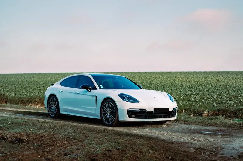 Porsche Panamera blanche au bord d'un champ