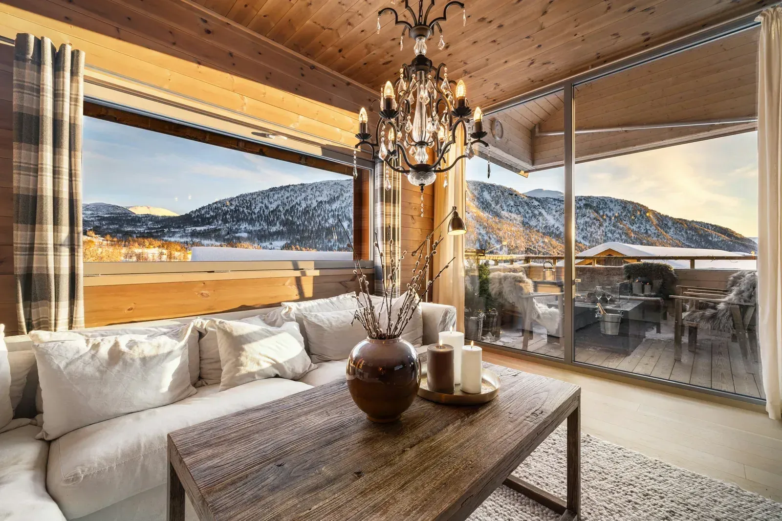 Salon de chalet chaleureux, grandes baies vitrées ouvertes sur les montagnes