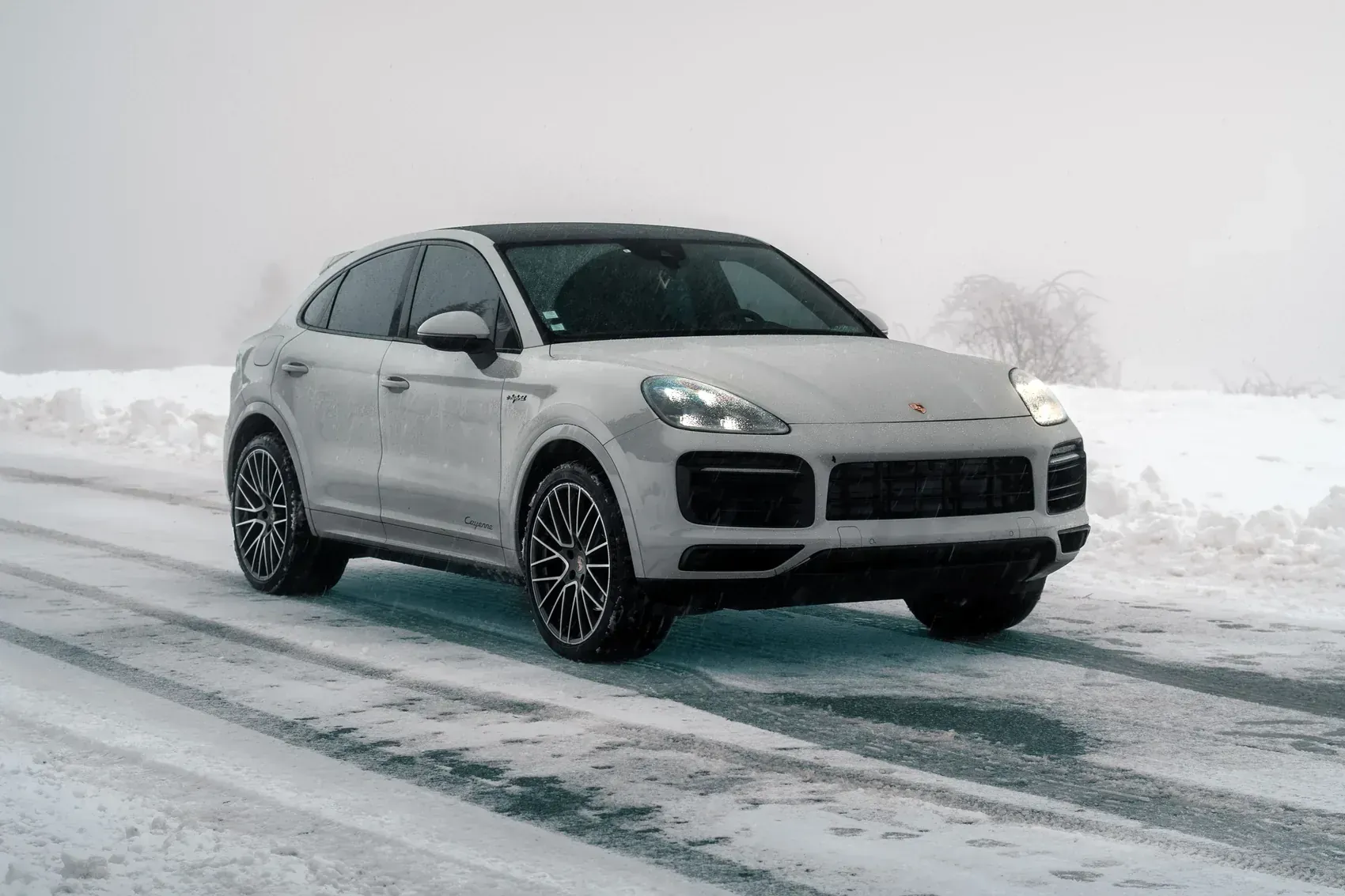 Porsche Cayenne blanc de la flotte Noctis sur une route enneigée