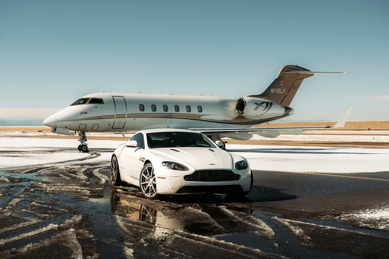 Jet privé sur le tarmac au coucher du soleil, voiture de sport blanche devant