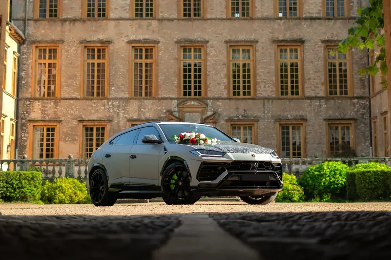 Lamborghini Urus fleurie devant la façade d'un château